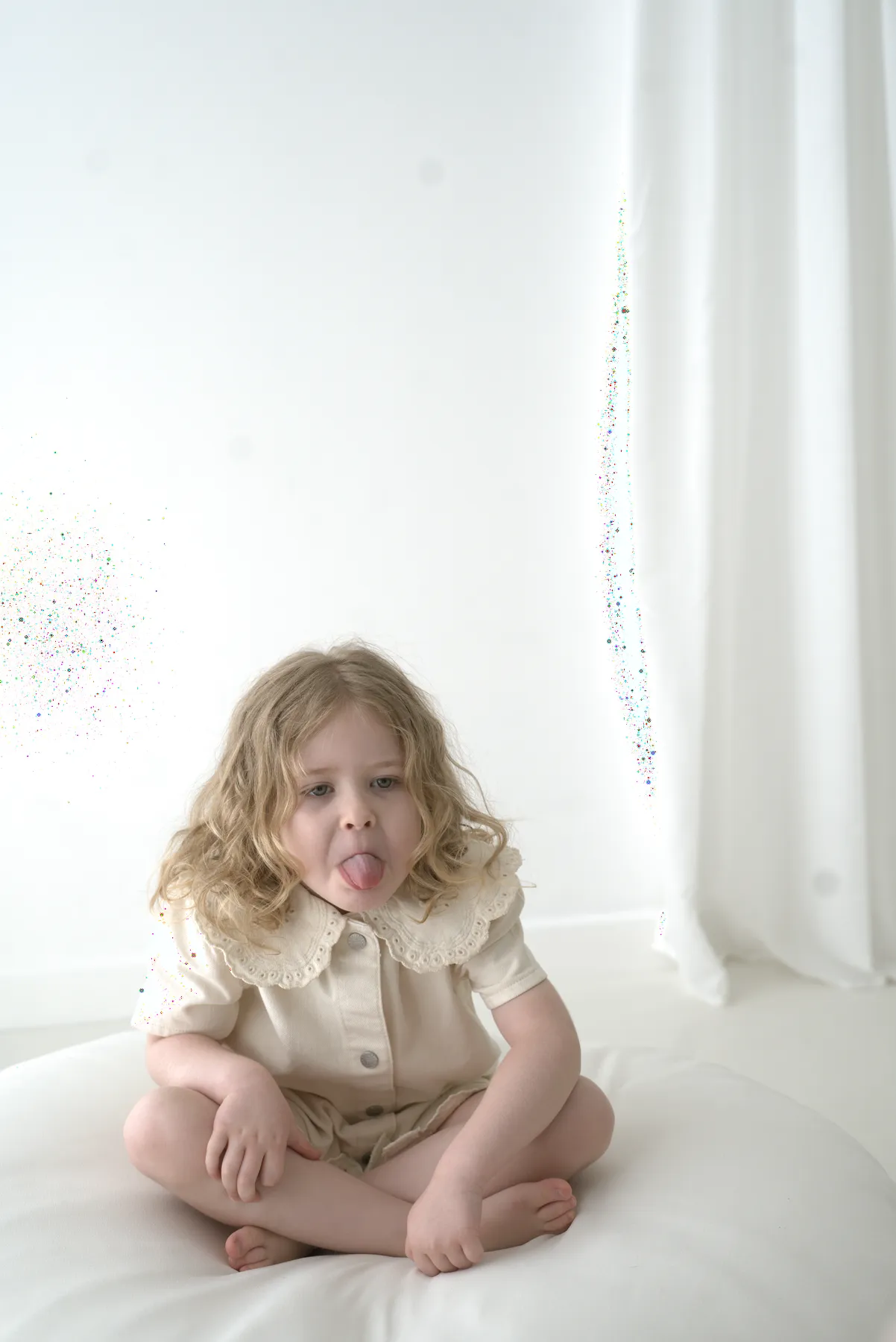 Young child seated in a neutral studio setting
