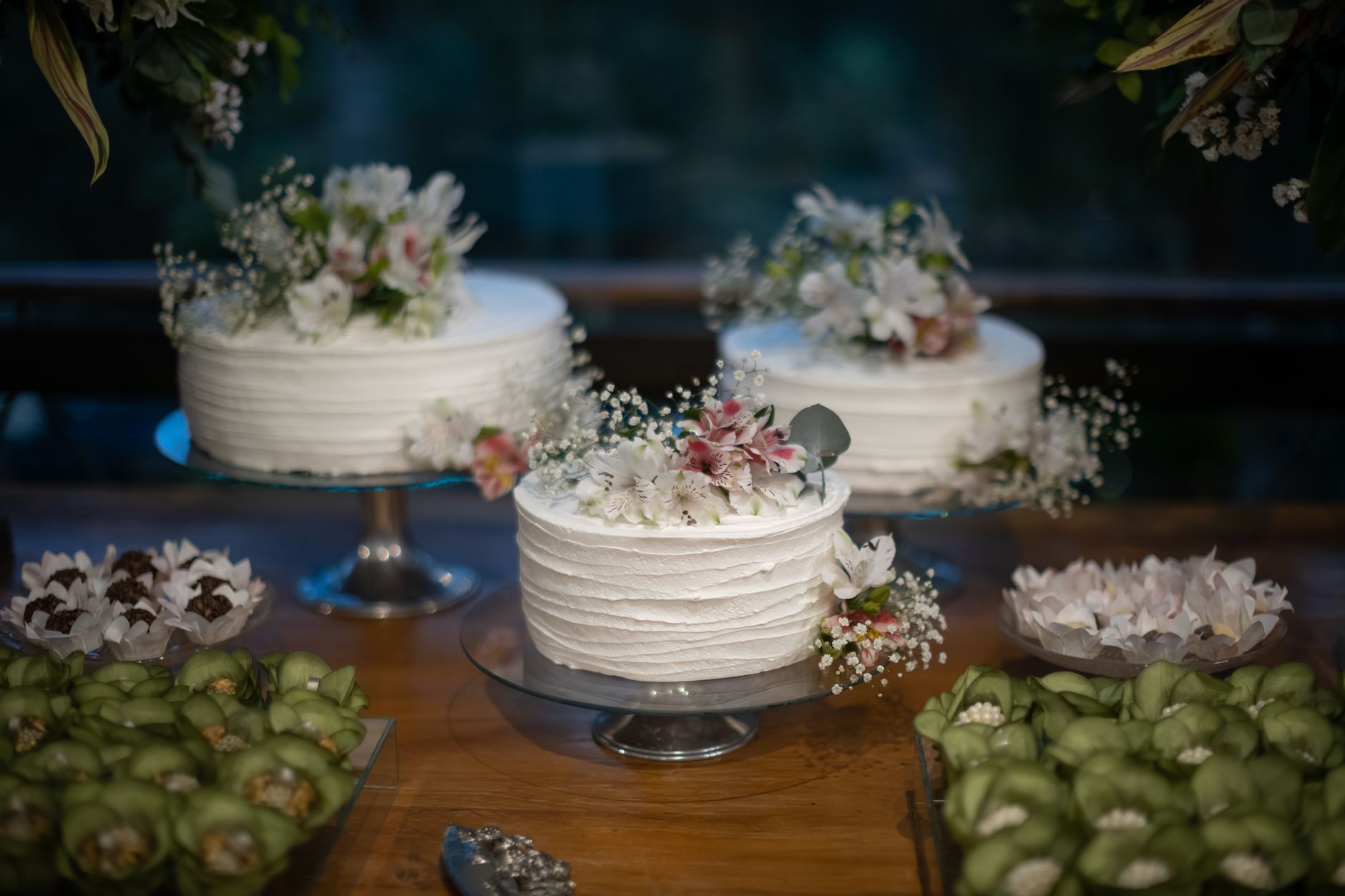 A display of white celebration cakes with soft floral details